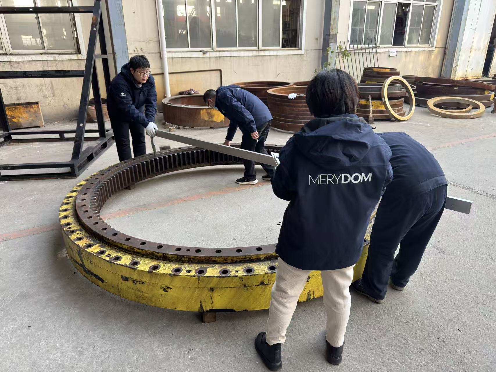 MERYDOM engineers measuring a large internal-gear three-row roller slewing bearing.