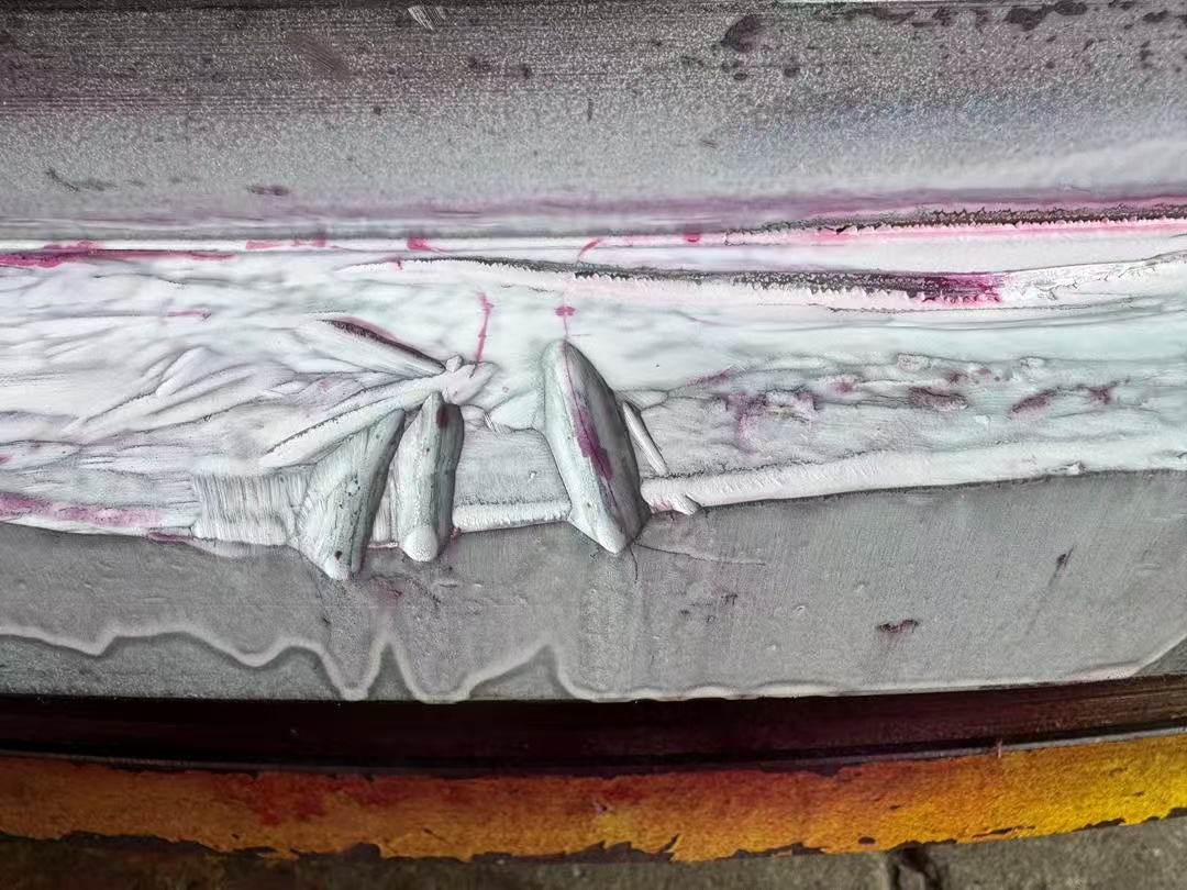Magnetic particle crack indications on a machined slewing bearing raceway.