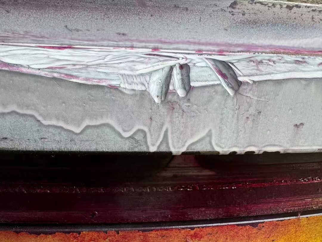Close-up magnetic particle inspection showing severe discontinuities in bearing ring material.