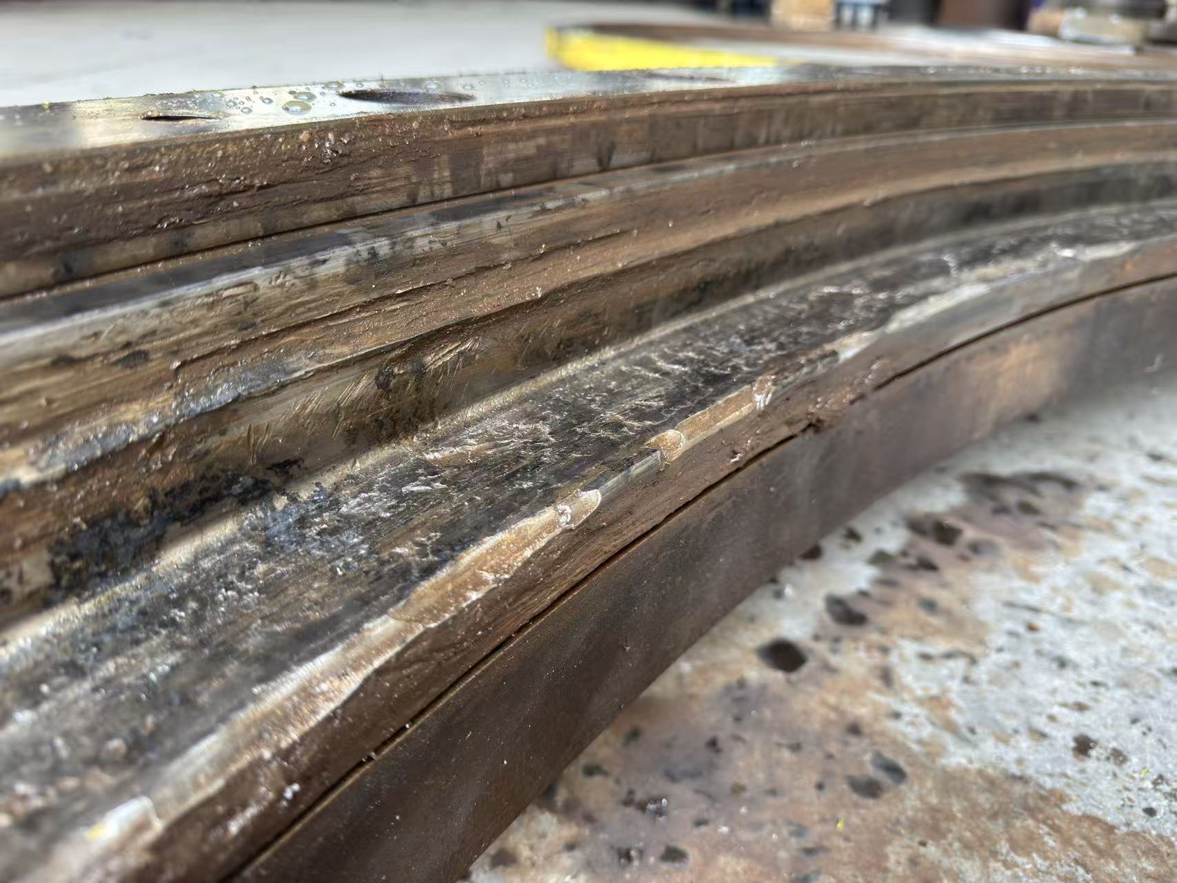 Close-up of severe wear, debris damage and deformation on a slewing bearing raceway.