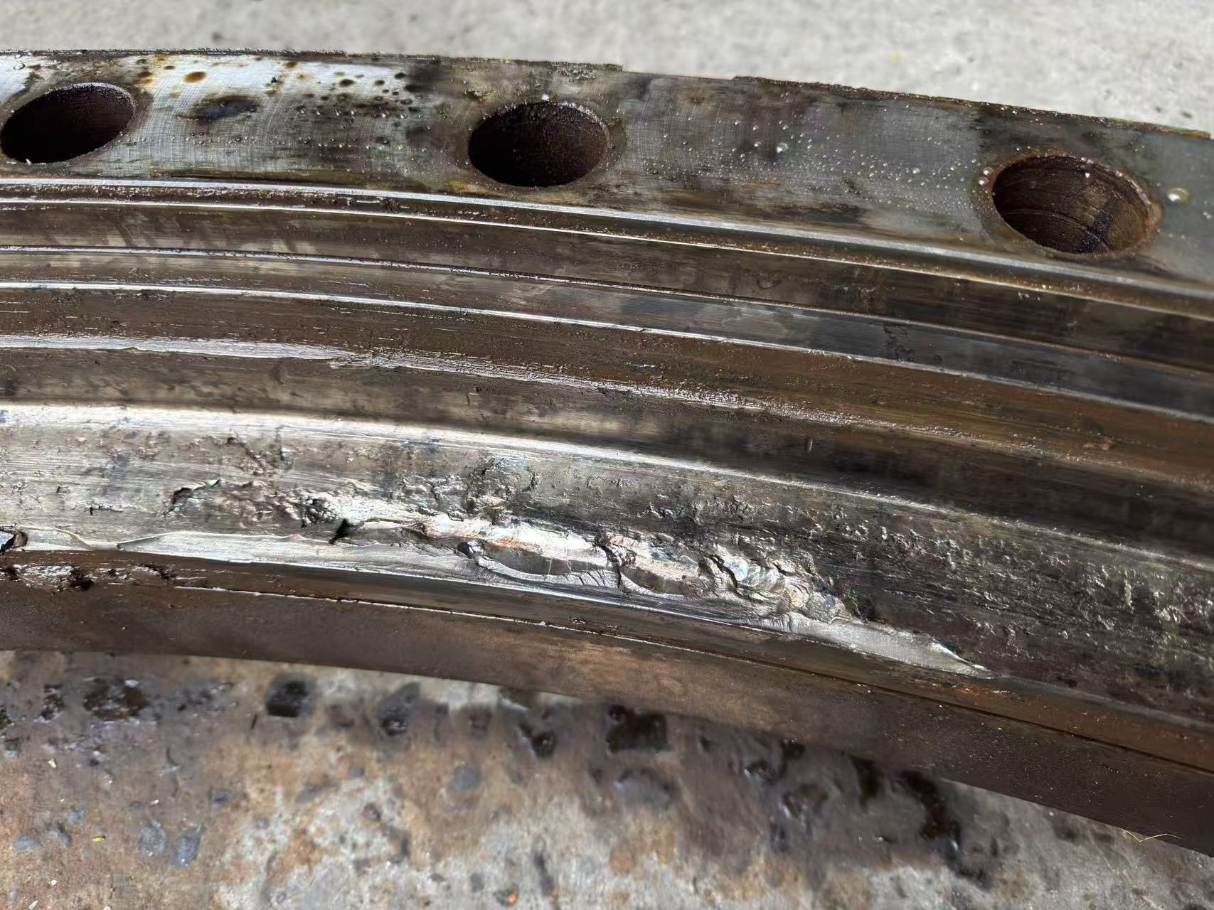 Severe spalling and material displacement on a port crane slewing bearing raceway.