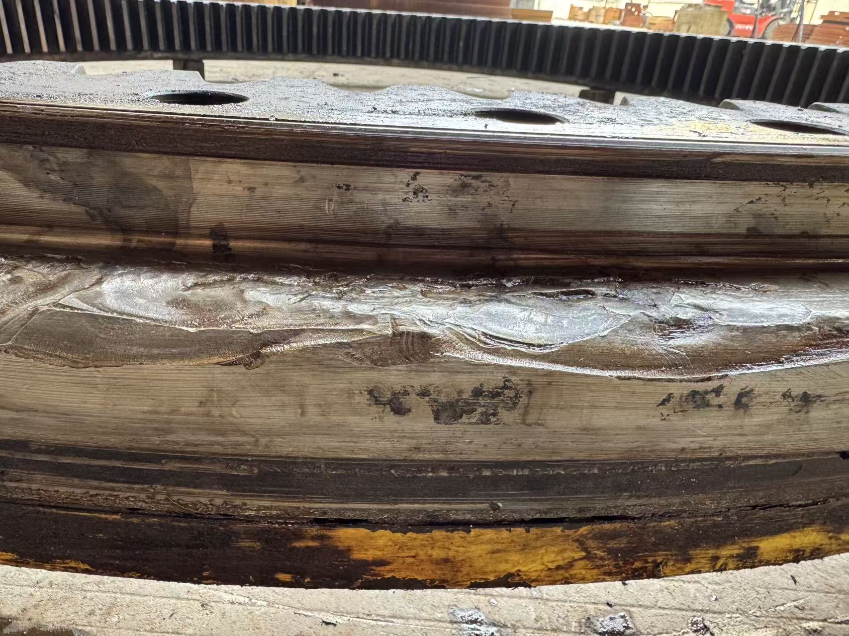 Extensive smeared metal and raceway destruction on a three-row roller slewing bearing.